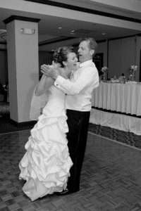 father and bride step on toes and laugh.jpg