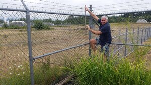 Garry climbing fence De Beers lightbox factory site.jpg