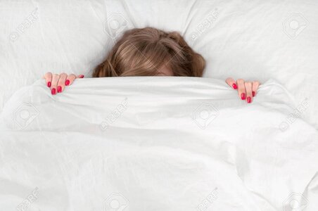 79388844-woman-hiding-under-blanket-on-bed-at-bedroom.jpg