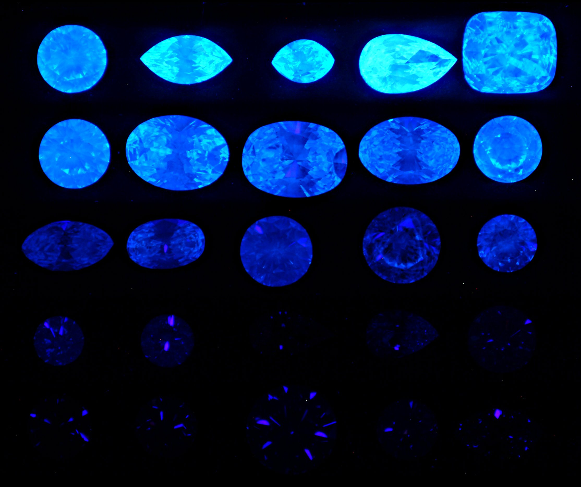 25-Diamond Data Base in Long Wave Ultraviolet “black-light” illumination. There are 5 rows of five diamonds with the five fluorescent strengths of None, Faint, Medium, Strong, and Very Strong blue fluorescence.