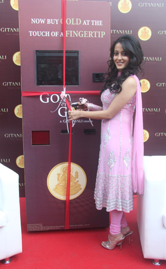 Bollywood star Raima Sen stands in front of Gitanjali Group's new ATM machine