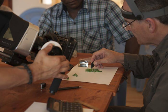 Roger Dery examines rough green garnets in the film. Image courtesy of Sharing the Rough.