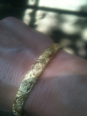 Wrist shot of Van Craeynest gold bangle bracelet