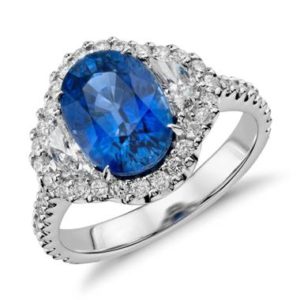 Blue sapphire and diamond halo three-stone ring set in 18K white gold at Blue Nile 