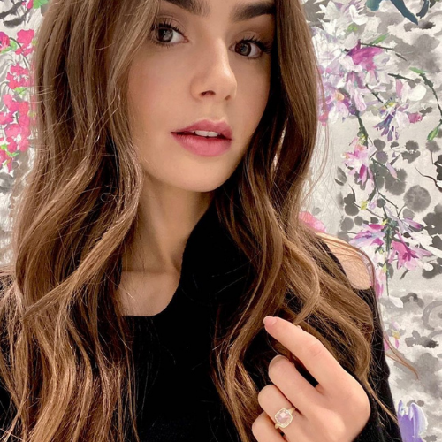 A 3 to 4 carat Rose cut engagement ring set in a yellow gold bezel setting on Lily Collins ring finger. 