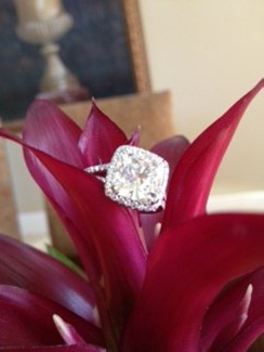 GIA certified 4.50 carat cushion cut diamond engagement ring placed on leaf.