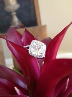 GIA certified 4.50 carat cushion cut diamond engagement ring placed on leaf. 