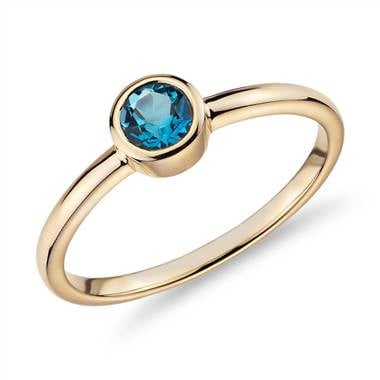 A Petite Bezel-Set Swiss Blue Topaz Ring in 14k Yellow Gold from Blue Nile.