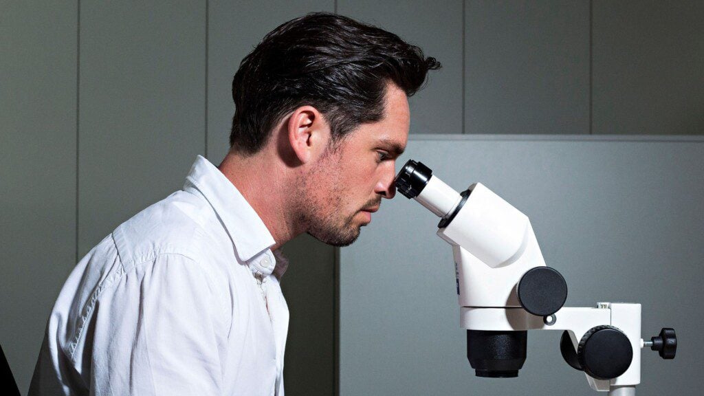 Gemologist using a gemstone grading microscope. Photo courtesy of IGI.