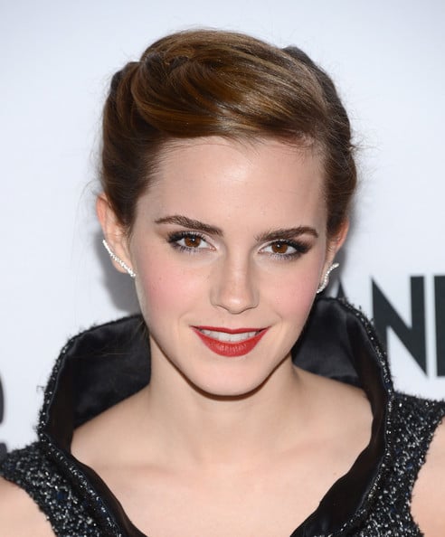 Emma Watson head and shoulders, hair in chignon, red lip, high color black top, Graziela Wave ear cuffs.