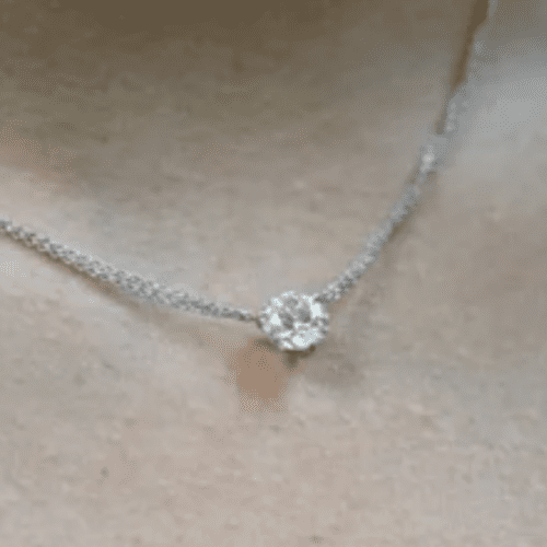 Round Brilliant Diamond Pendant on double chain against creamy white skin. 