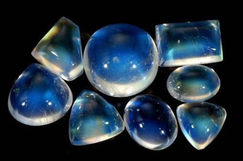 8 moonstones of varying shapes and sizes on a black background
