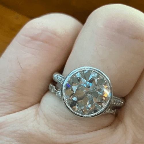 Large round diamond ring in bezel on a finger