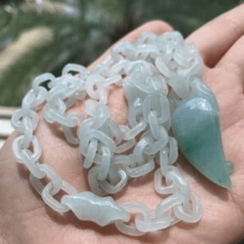 jadeite devil's work necklace, very pale greed interwoven chain with a pendant that resembles a chili pepper