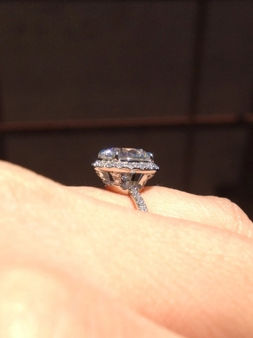 Profile of a diamond ring in halo on a finger.