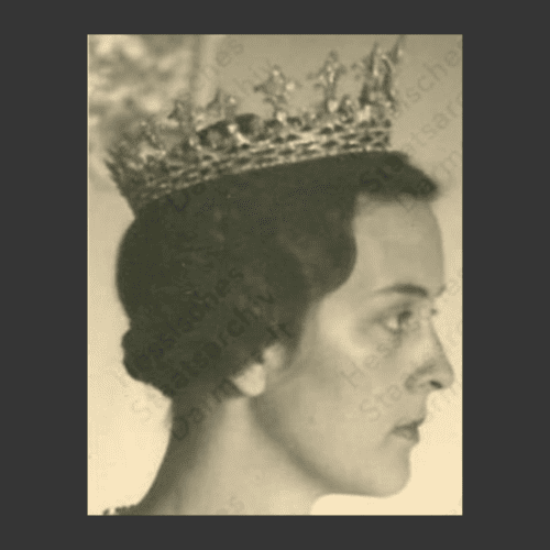 A black and white image of a woman's face in profile, wearing a tiara.