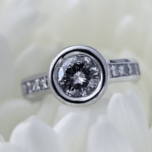 Diamond ring in bezel sitting in white flower petals.