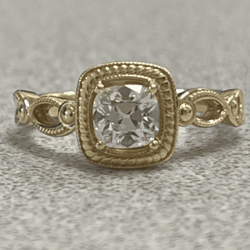 Gold and diamond ring sitting on what llooks like a countertop.