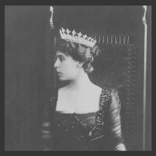 A black and white image of a woman in profile, dressed in black, wearing a tiara.
