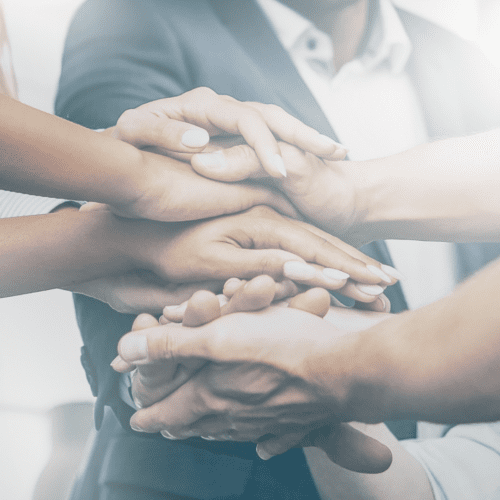 A group of people with their hands stacked in teamwork