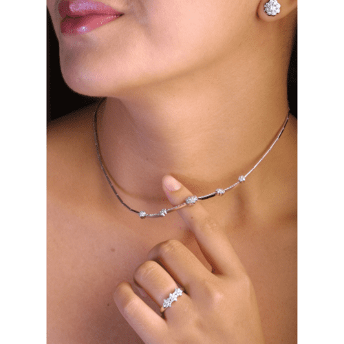 woman chin, neck, shoulders, and one hand. Wearing an earring, necklace, and ring.