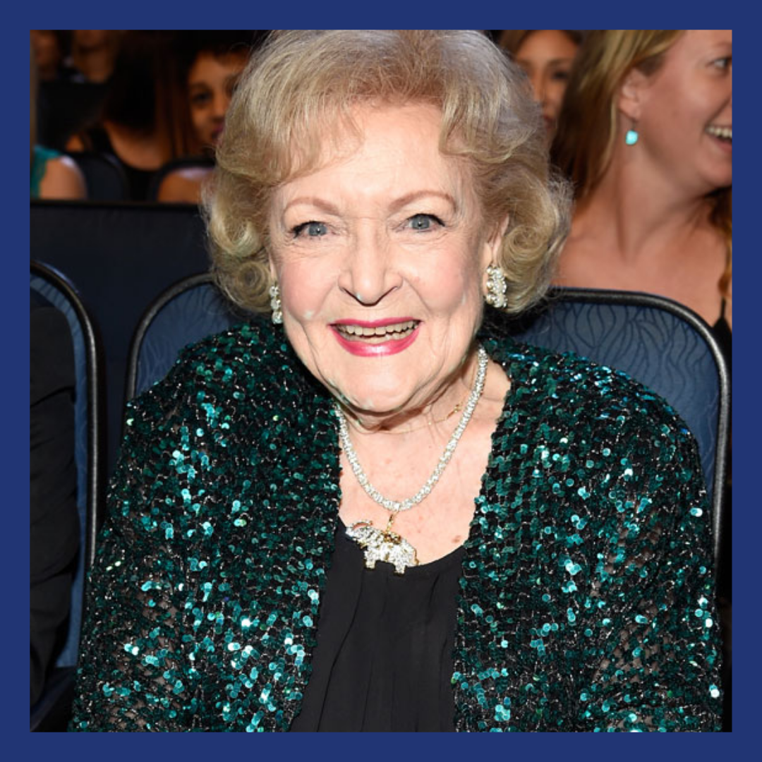 Older woman on a rin a green sequined jacket in the audience at an awards show.