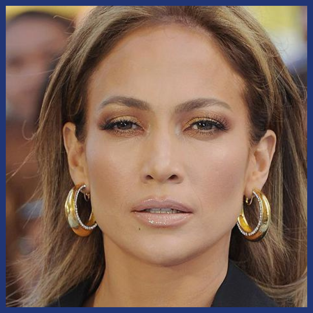 Woman smiles at the viewer with hoop earrings.
