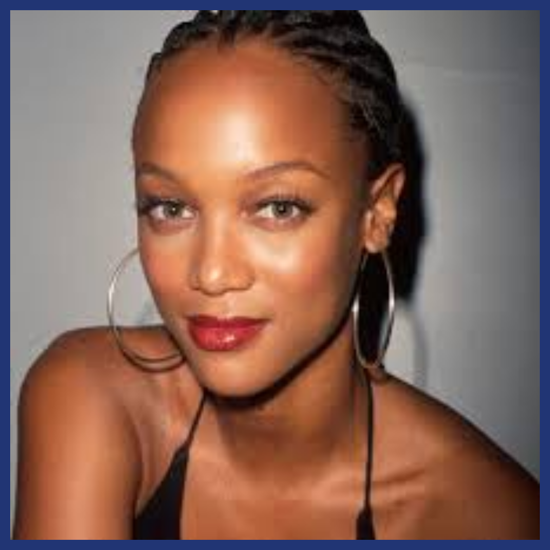 Black woman in braids and hoop earrings smiling at the viewer.