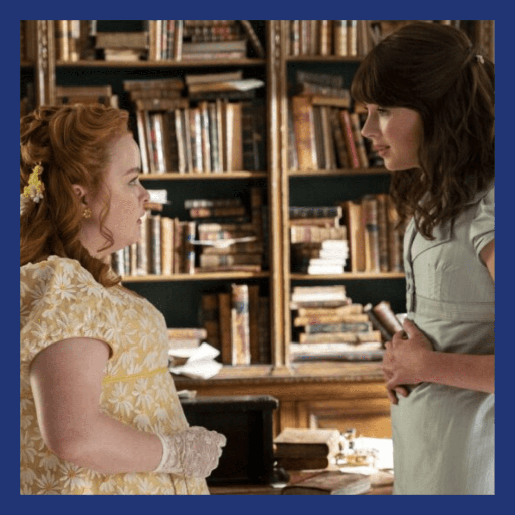 a couple of white women talking in a library, wearing regency era costumes.