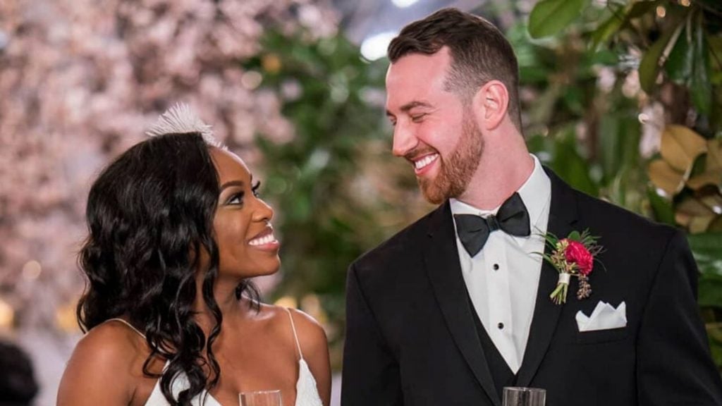 A black woman gazes up into the eyes of her white male partner. Love is in the air.