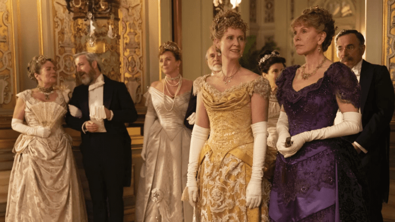 many people in a ballroom in period costuming.