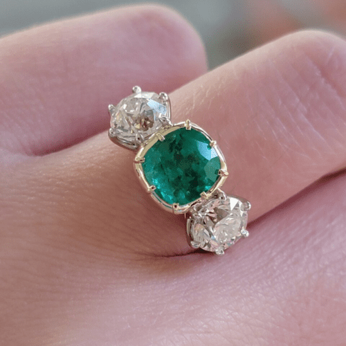Emerald and diamond three-stone ring.