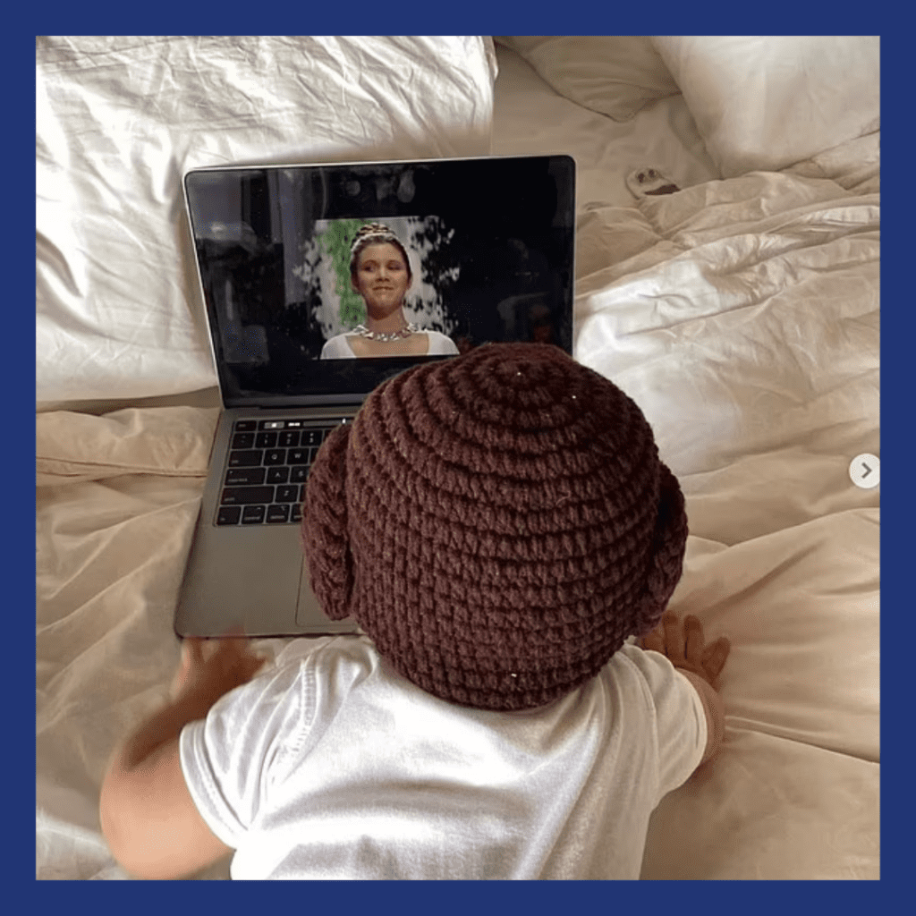 Baby watching star wars on a laptop screen.
