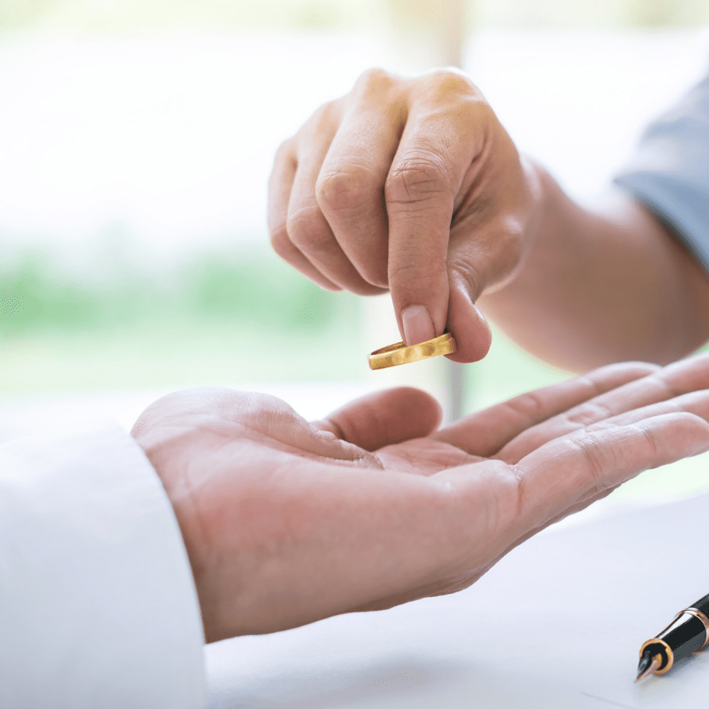 Close up of hands handing over a ring from one to the other.