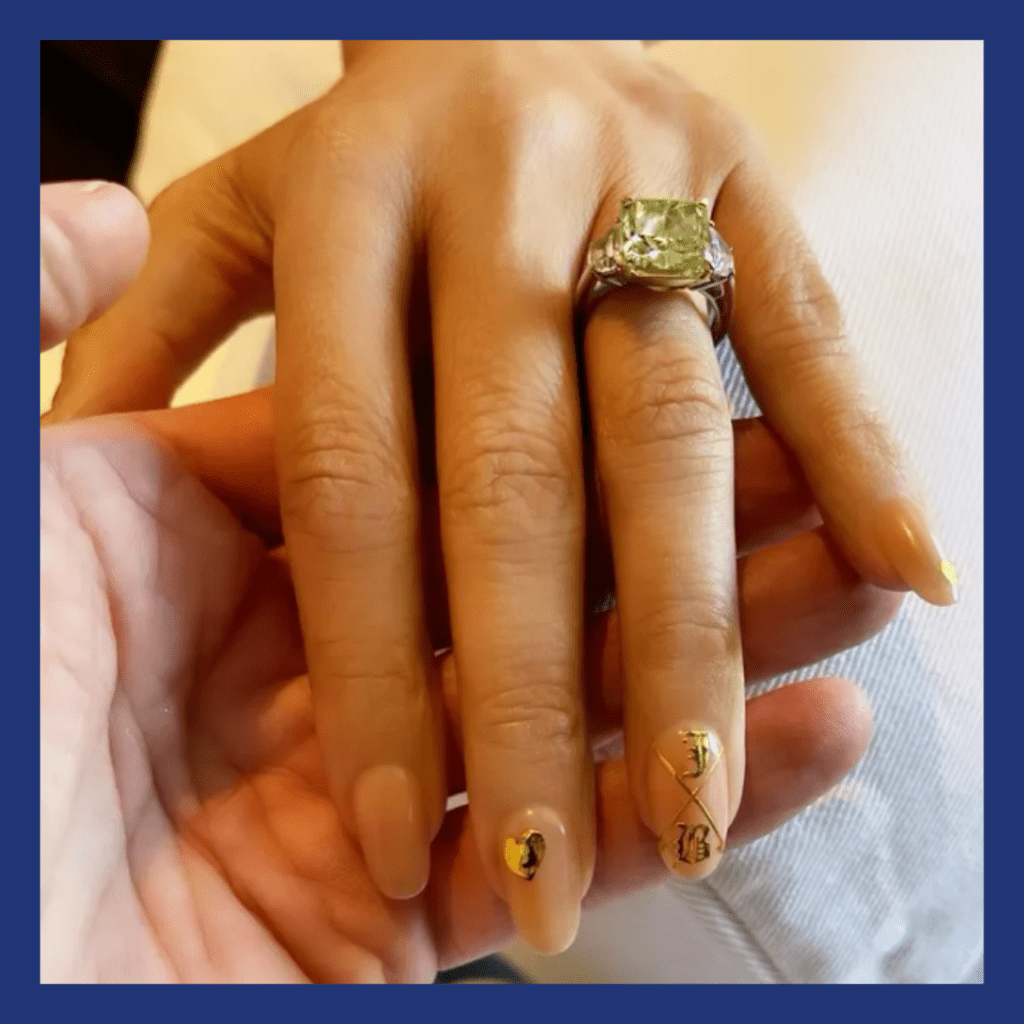 JLo's hand with a green diamond ring