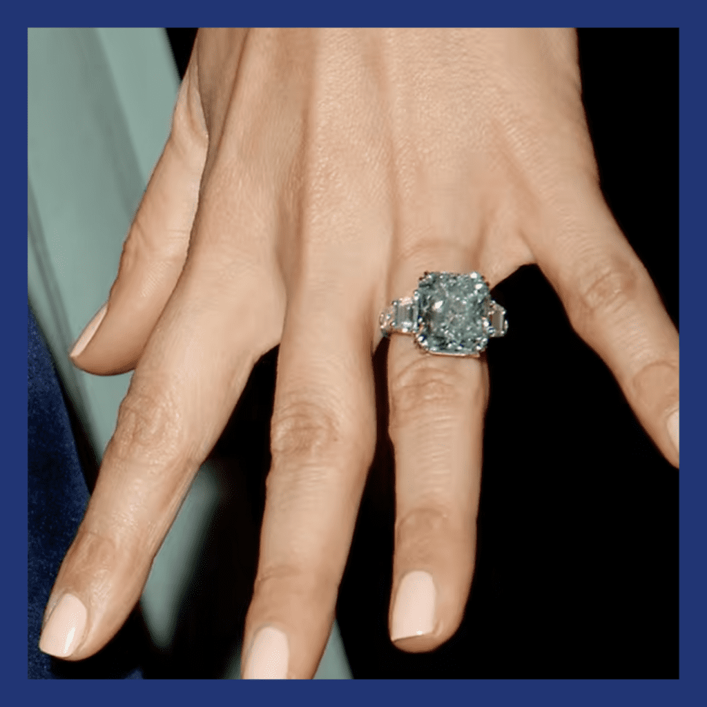 JLo's hand with blue diamond ring