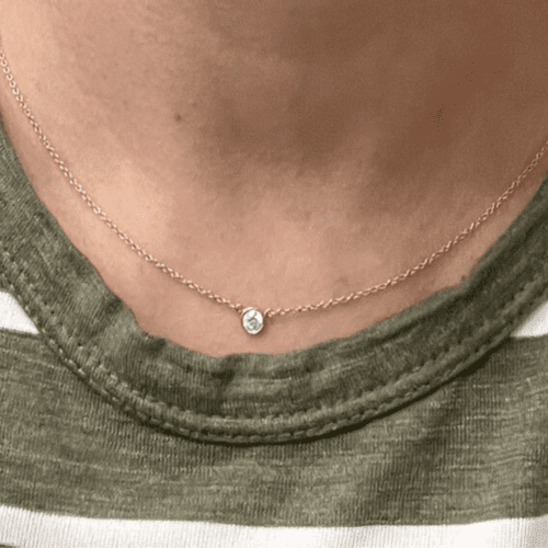 Tiffany diamond pendant on a neck with a green and white striped shirt