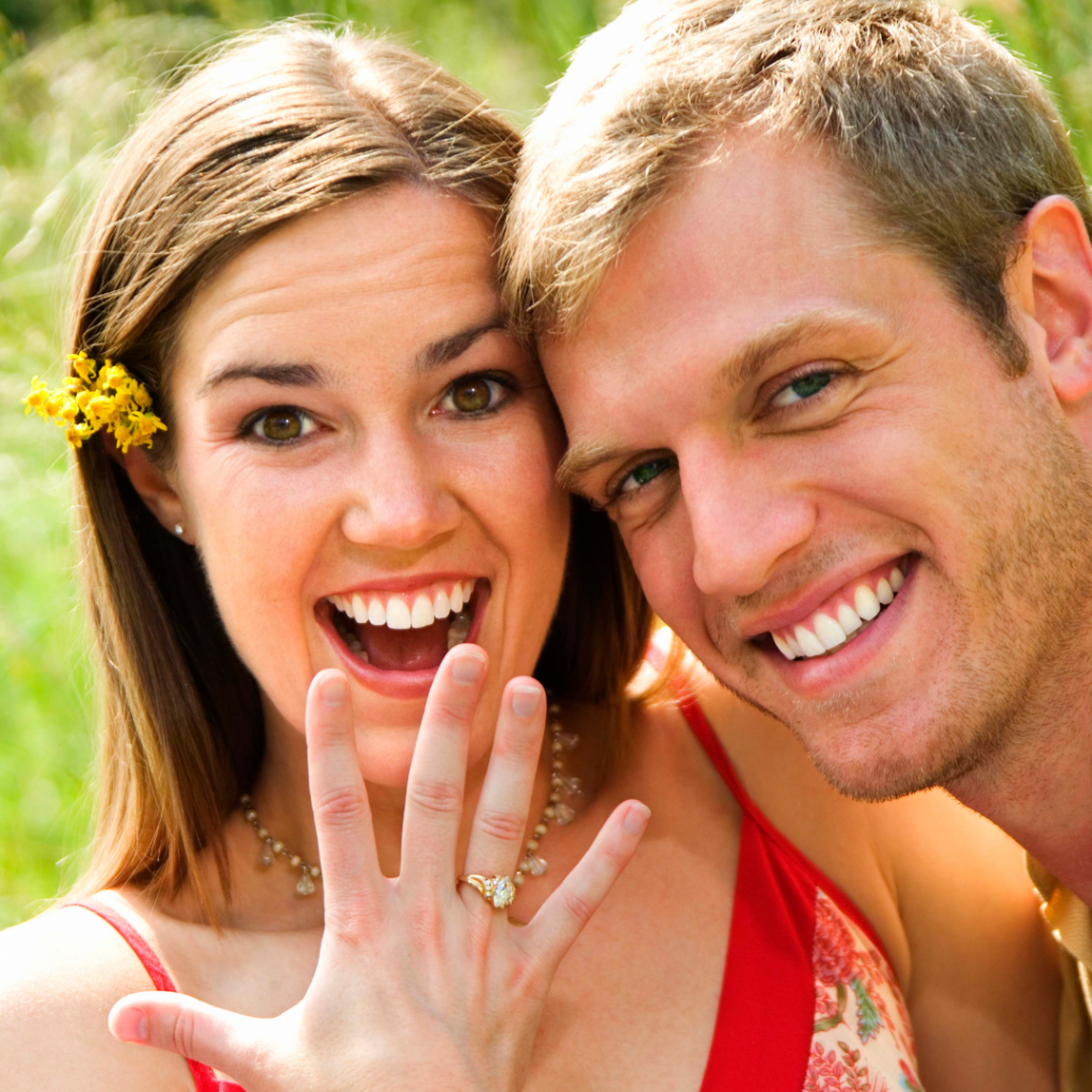 happy smiling couple showing engagement ring