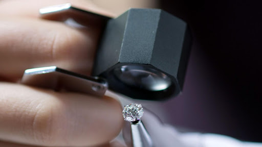 Close up image of expert examining and grading a diamond in a lab