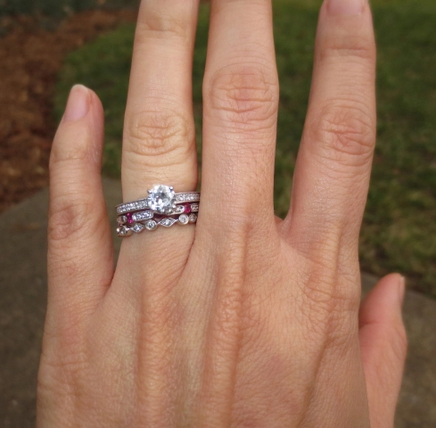 Woman showing off her large engagement ring and wedding ring on the same finger