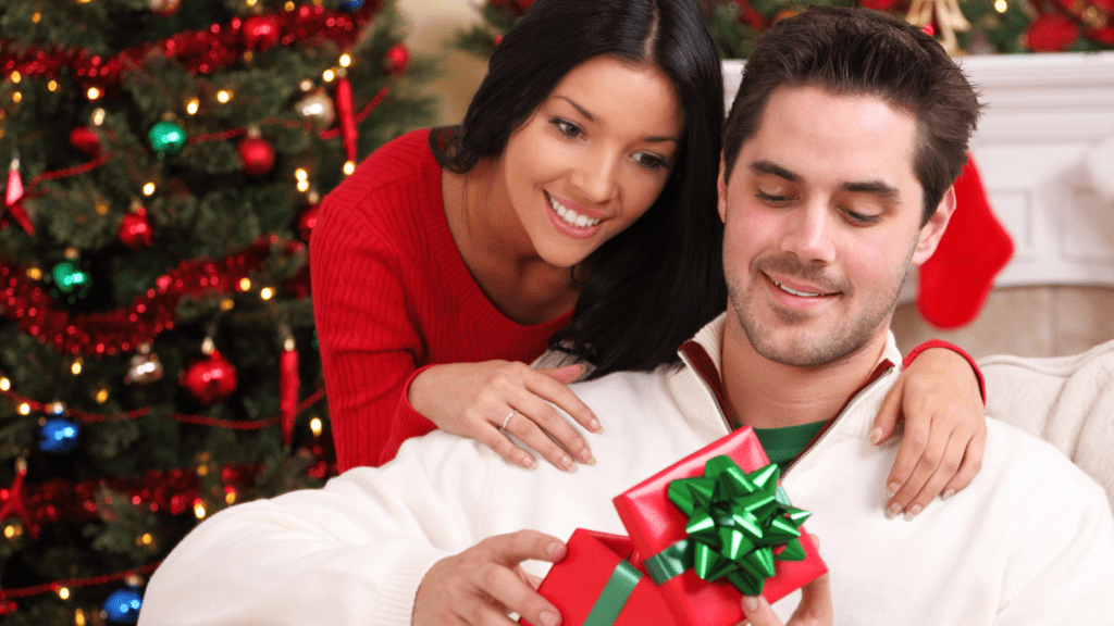 Happy couple - man is opening gift from woman.