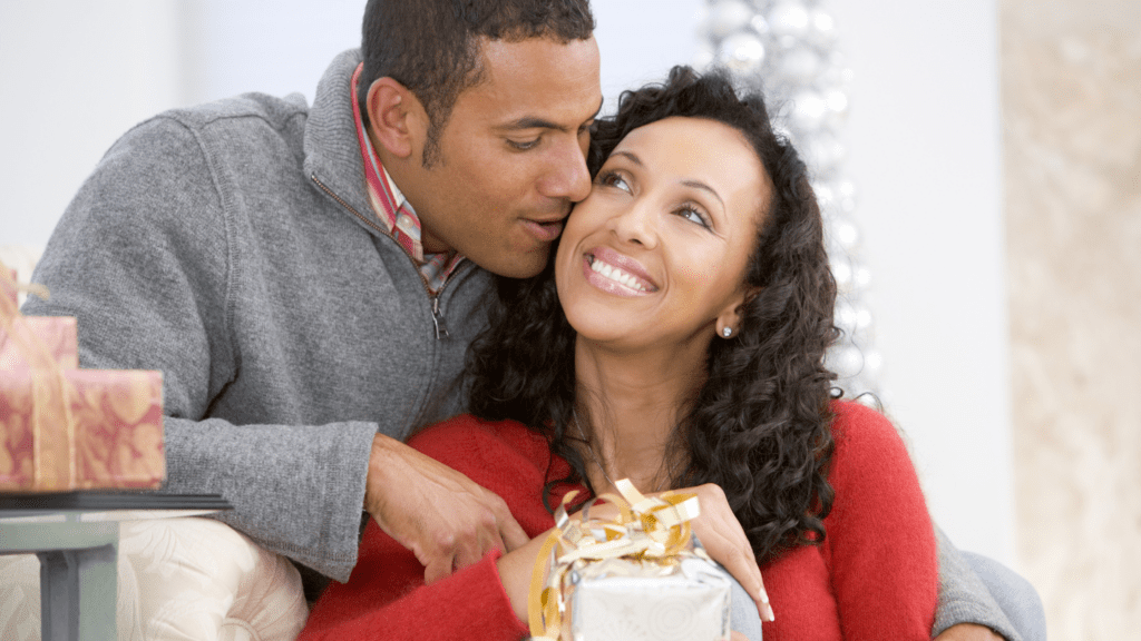 Happy couple - wife is opening gift from husband