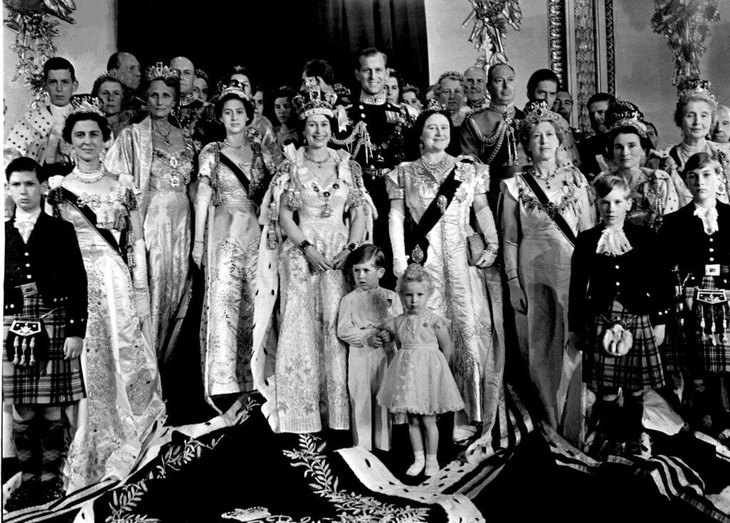 Queen Elizabeth II in her Coronation robes photographed with her family and other members of the Royal Family, in the Throne Room at Buckingham Palace.