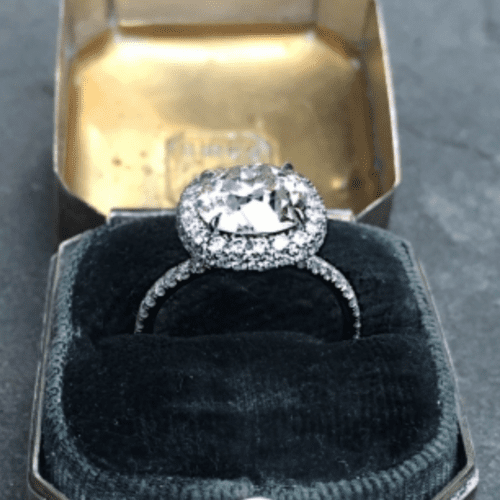 Antique cushion diamond ring in a two-sided halo setting