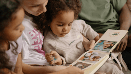 Mother and daughters viewing a photo album.