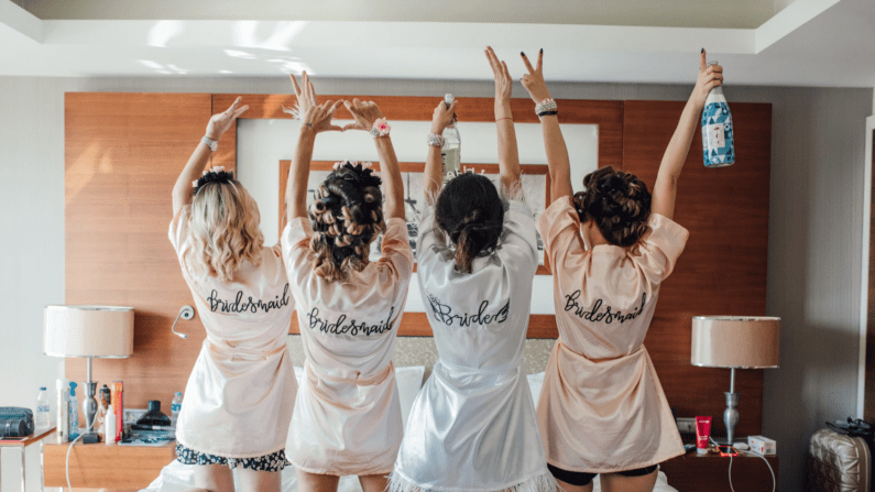 bridesmaids all cheering wearing matching robes.