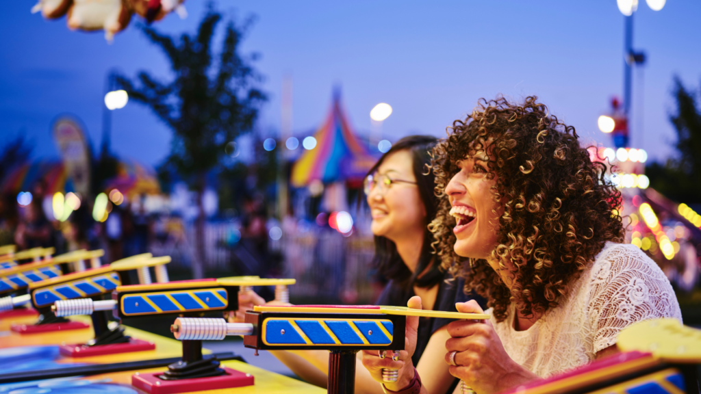 Two women playing a carnival game