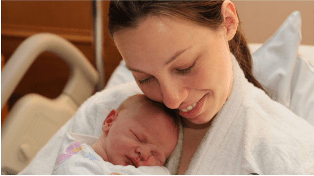Lady holding newborn baby in the hospital